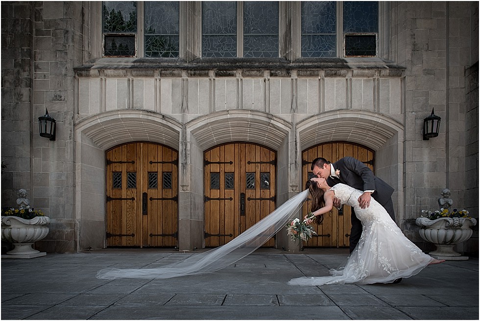 Bride and groom kiss at Boystown with veil blowing