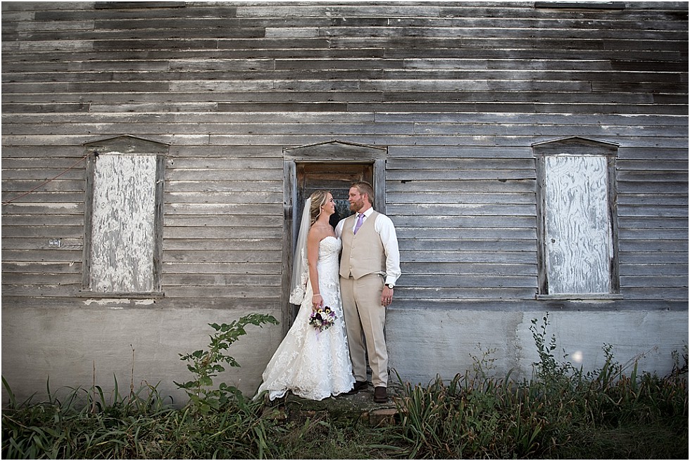 bride and groom in front of abandoned house