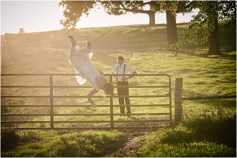 bride jumping over cattle fence