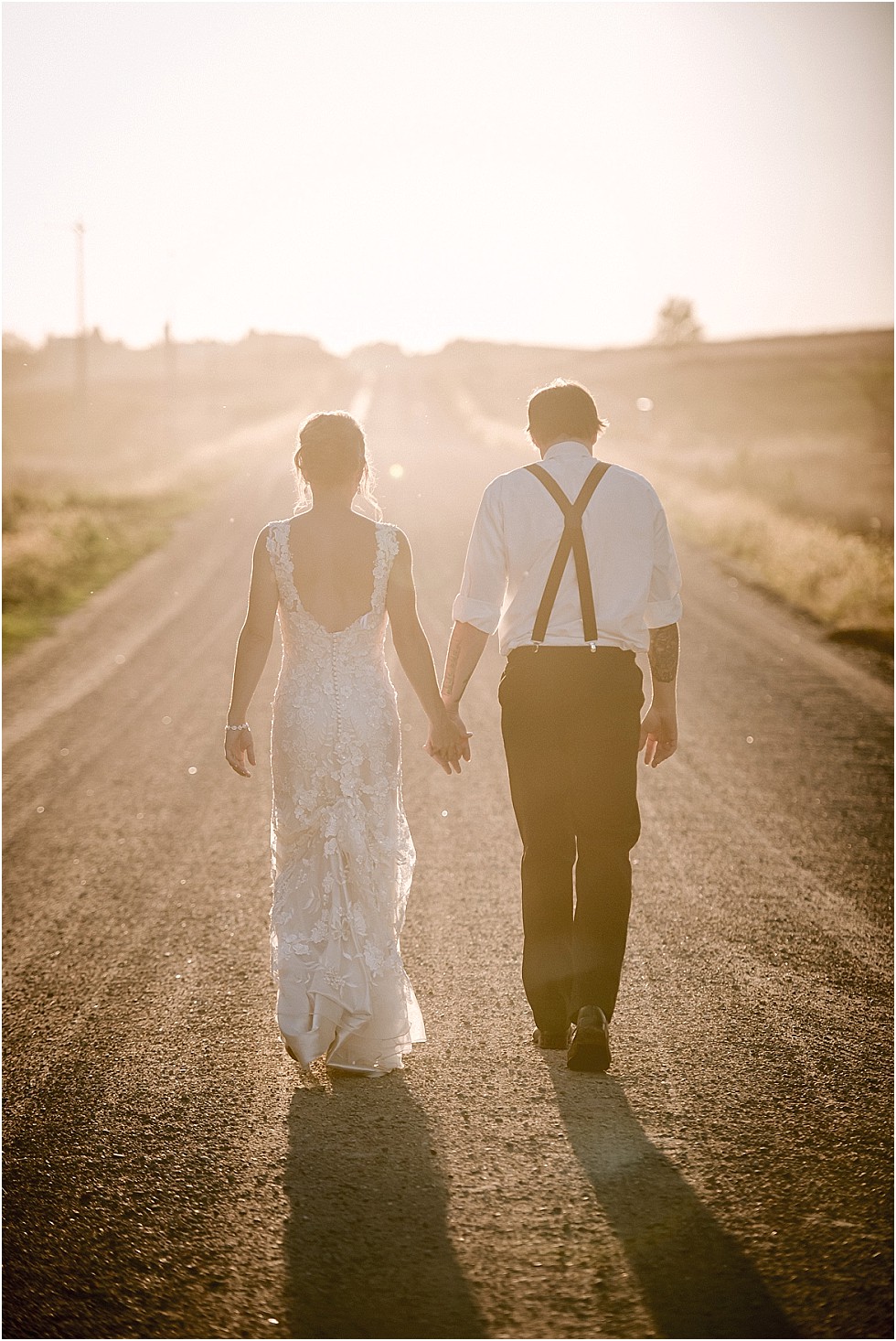 bride and groom sunset walk on gravel road