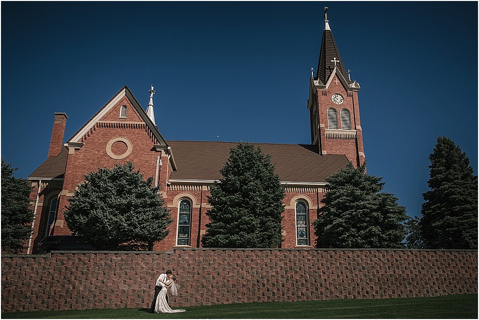 bride and groom kiss in front of Saint Peter and Paul church Bow Valley Nebraska