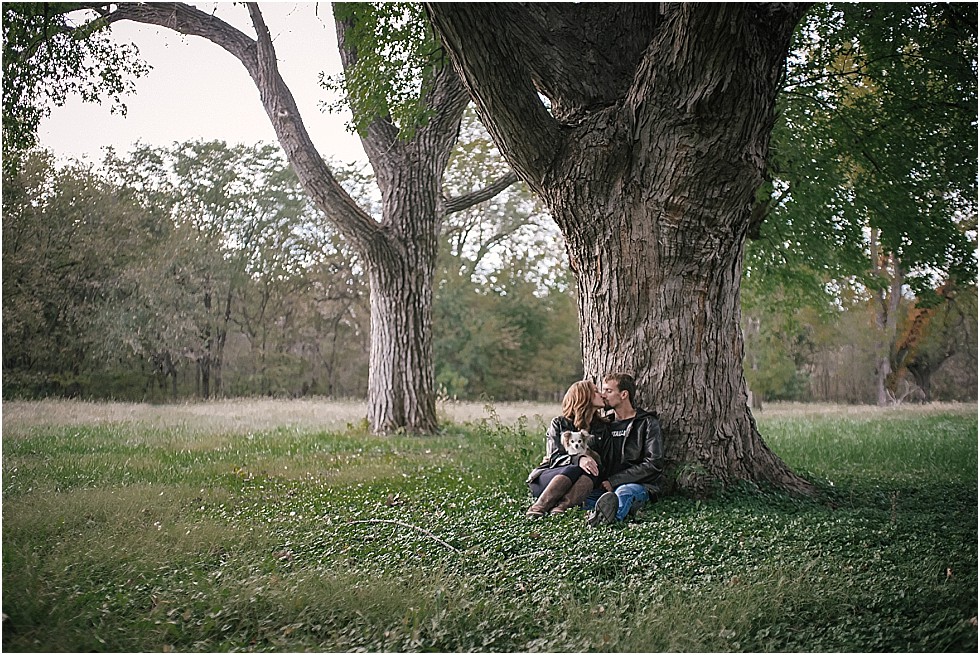 couple kiss under tree engagement shoot