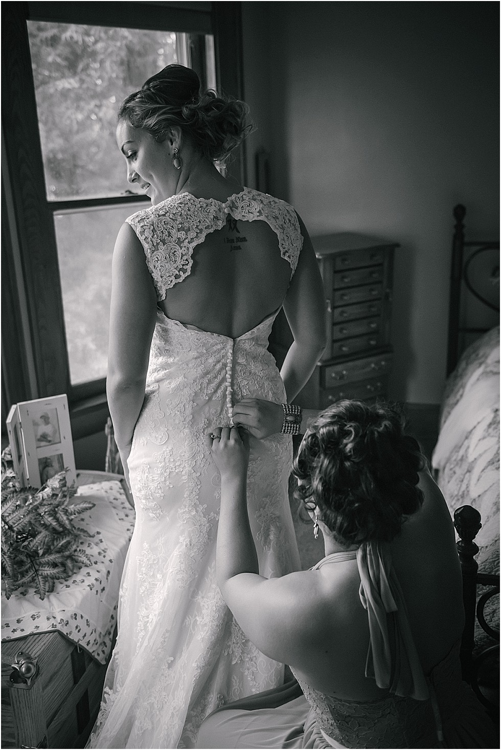 sister helping bride get into wedding dress