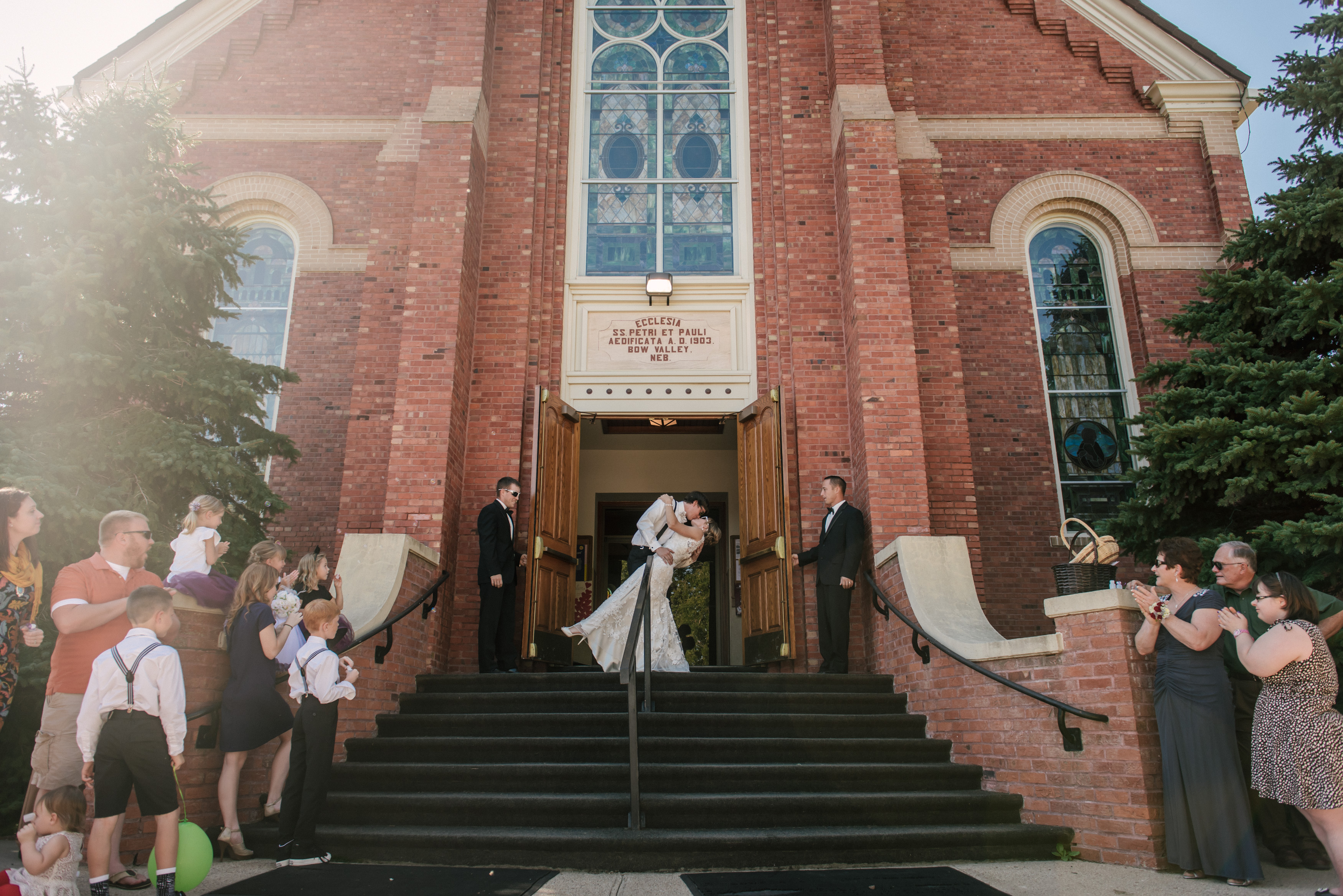 bride and groom kiss while exiting church